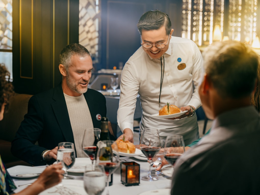 Waiter serving food at Crown Grill