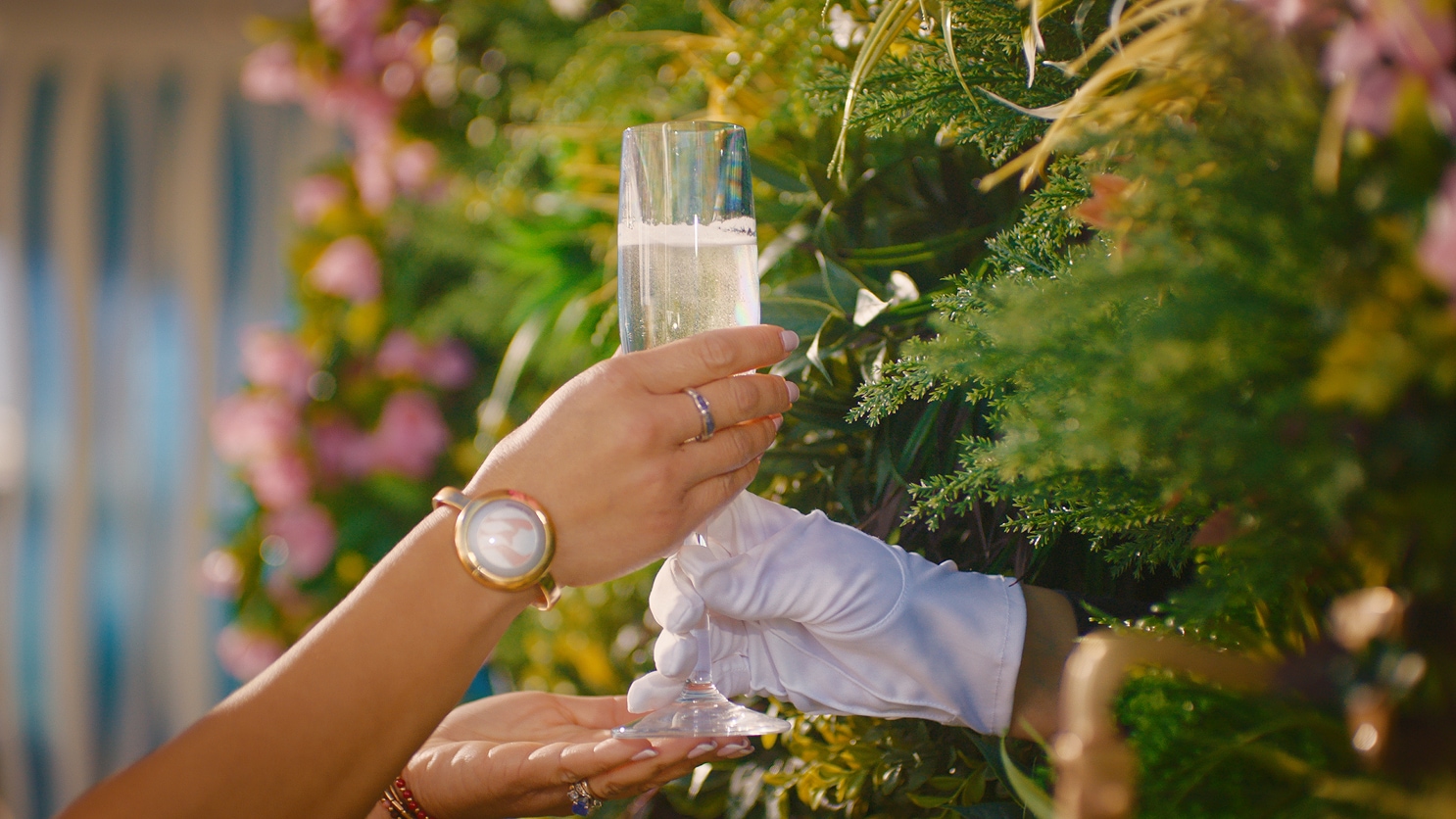 Person serving a glass of champagne