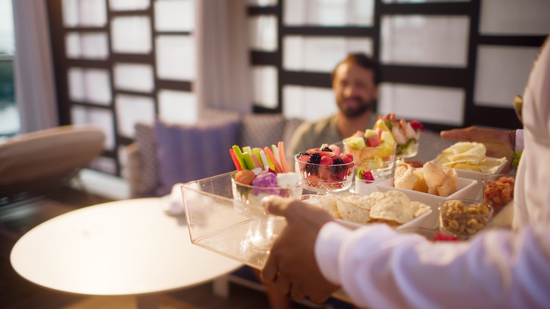 Person carrying a tray with chips and fruit